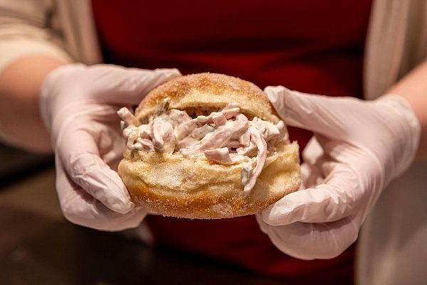 Der «Wetterauer Flaaschworscht-Kreppel mit hausgemachtem Worschtsalat» (hochdeutsch: Fleischwurst-Kreppel mit hausgemachtem Wurstsalat) ist die neueste Kreation der Stadtbäckerei Rank für die Karnevalssaison 2024. - © Christian Lademann/dpa