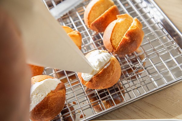 Aus Puderzucker, echter Vanille und Vollrahm wird die Creme hergestellt, die als Füllung in die herausgeschnittenen Slots der Maritozzo Romano gefüllt wird. - © Christin Klose/dpa-tmn