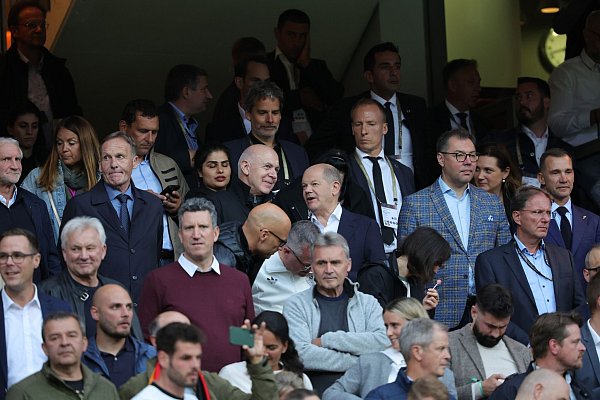 Bundeskanzler Olaf Scholz (M) und DFB-Präsident Bernd Neuendorf unterhalten sich vor Beginn der Partie. - © Christian Charisius/dpa