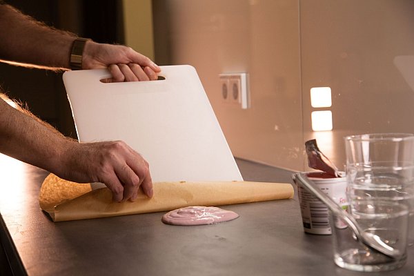 Schritt 1: Backpapier und Schneidebrett am Klecks ansetzen. - © Christin Klose/dpa-tmn