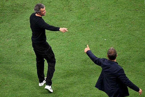 Hansi Flick (r) hat nichts über das Gespräch mit Spaniens Coach Luis Enrique verraten, aber die Gesten sind vielsagend. - © Robert Michael/dpa