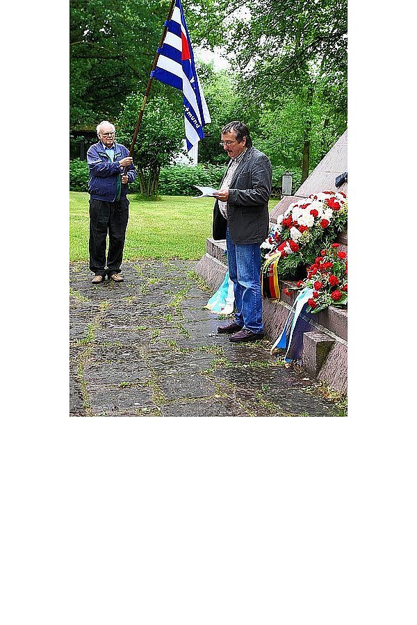 Vorsitzender des Arbeitskreises Hubert Kniesburges (rechts) gedenkt den Opfern. Unterstützend hält Günter Bennardt die Vereinsfahne des VVN-BdA. - © FOTO: KATRIN EWERT