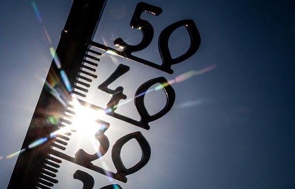 Vor einem wolkenlosen blauen Himmel zeigt ein Außenthermometer in einem Garten bereits am Vormittag über 30 Grad Lufttemperatur an. (Illustration) - © Jens Büttner/dpa
