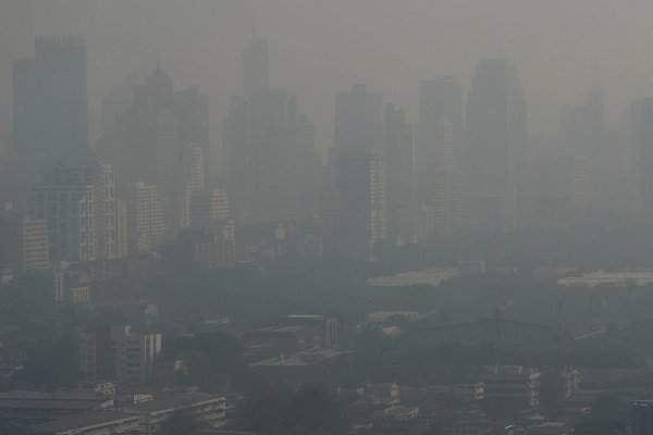 Die Hochhäuser der Metropole sind wegen der Luftverschmutzung kaum sichtbar. - © Sakchai Lalit/AP/dpa