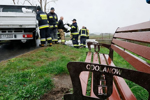 Feuerwehrleute in Polen errichten mit Sandsäcken eine Barriere gegen das drohende Hochwasser in der Nähe des Flusses Barycz in Odolanow. - © Tomasz Wojtasik/PAP/dpa