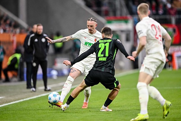 Augsburgs Marius Wolf spielt den Ball an Joakim Maehle von Wolfsburg vorbei. - © Harry Langer/dpa