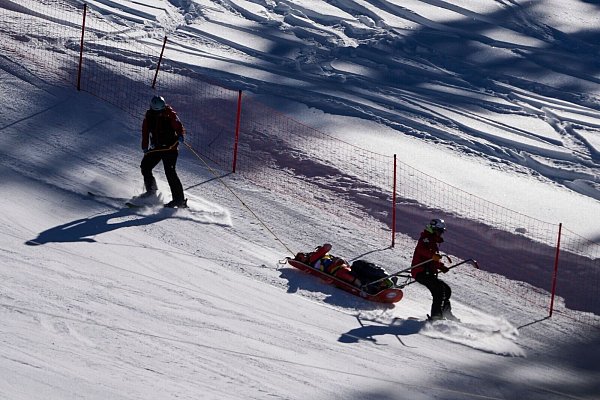 Der Schweizer Boisset stürzte schwer und wurde mit einem Rettungsschlitten abtransportiert. - © John Locher/AP/dpa