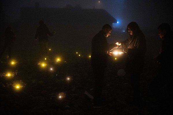 In Antakya entzündeten Menschen Kerzen auf den Ruinen der zerstörten Gebäude in Gedenken an die dort Getöteten und warfen rote Nelken in den Fluss der Stadt. - © Boris Roessler/dpa