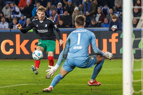 Magdeburgs Philipp Hercher (l) zieht ab gegen Torwart Ron-Thorben Hoffmann von Eintracht Braunschweig. - © Andreas Gora/dpa