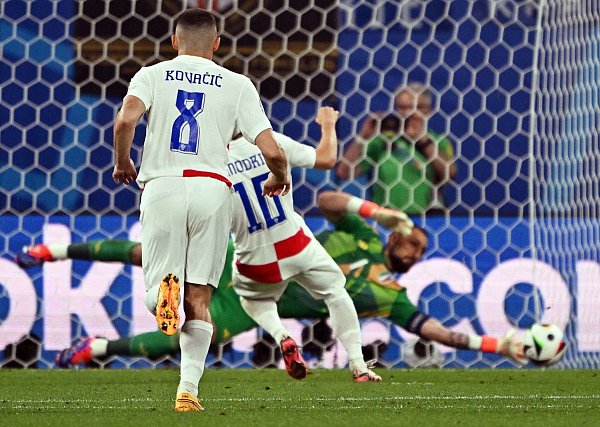 Italiens Torhüter Gianluigi Donnarumma (hinten) hält einen Elfmeter von Luka Modric. - © Robert Michael/dpa