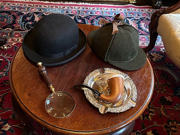 Er kommt jeden Moment zurück: Hüte, Lupe und Pfeife im Sherlock-Holmes-Museum. - © Benedikt von Imhoff/dpa