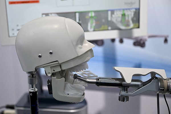 Roboter könnten in Zukunft auch an Zahnimplantaten arbeiten. - © Johannes Neudecker/dpa