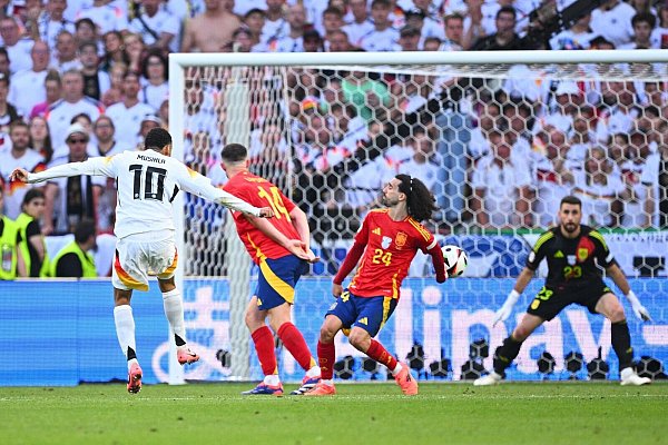 Jamal Musiala schießt - und Spaniens Marc Cucurella wehrt den Ball im EM-Viertelfinale mit dem abgespreizten Arm ab. - © Tom Weller/dpa