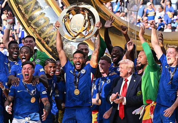 US-Präsident Donald Trump bleibt einfach bei den Chelsea-Spielern auf dem Siegerpodest und applaudiert ihnen. - © Sven Hoppe/dpa