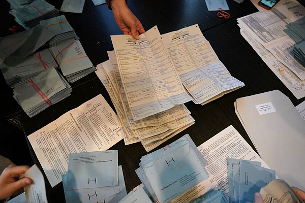 Wahlhelfer sortieren bei der Stimmenauszählung die Wahlzettel. - © Marcus Brandt/dpa