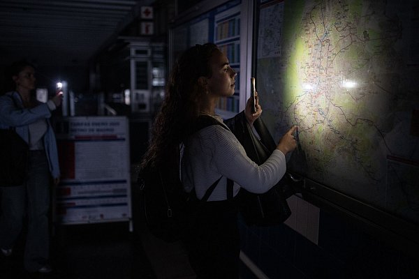 Eine Frau behilft sich mit der Taschenlampe ihres Handys, um den Plan des Madrider U-Bahn-Netzes anschauen zu können. - © Alejandro Martínez Vélez/EUROPA PRESS/dpa