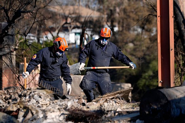 In den Brandruinen wird auch noch nach möglichen Opfern gesucht. - © Richard Vogel/AP/dpa