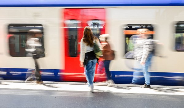 Fahrgäste stehen am Hauptbahnhof Hannover vor einer einfahrenden S-Bahn. - © Julian Stratenschulte/dpa