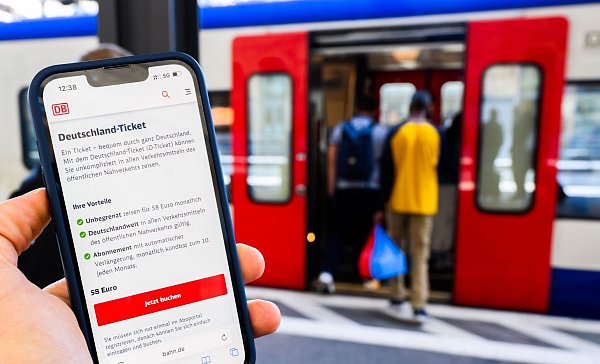 Eine Information zum Kauf des Deutschlandtickets ist auf dem Display eines Smartphones am Hauptbahnhof Hannover zu sehen. (Illustration) - © Julian Stratenschulte/dpa