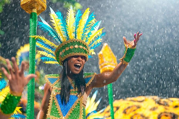 Eine Tänzerin der Sambaschule Barroca Zona Sul präsentiert sich mit gelb-blauem Federschmuck. - © Andre Penner/AP/dpa