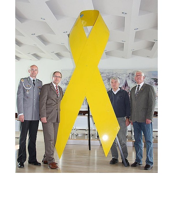 Dazu rufen David Lohse, Kreisvorsitzender des Reservistenverbandes, Landrat Manfred Müller, Dieter Dembeck, Bezirksvorsitzender der ehemaligen Soldaten, und Karl-Heinz Schwarze vom Reservistenverband (v. l.) - hier mit gelber Schleife im Großformat - auf. - © FOTO: KREIS PADERBORN