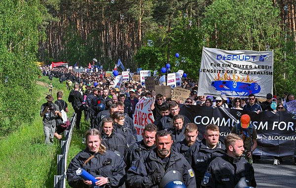 Polizistinnen und Polizisten begleiten den Protestmarsch. - © Patrick Pleul/dpa