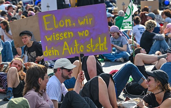 Die Protestierenden nehmen auch Tesla-Chef Elon Musk aufs Korn. - © Patrick Pleul/dpa