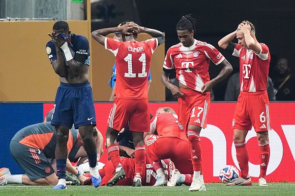 Bestürzte Teamkollegen und Gegenspieler nach der Musiala-Verletzung. - © Mike Stewart/AP/dpa