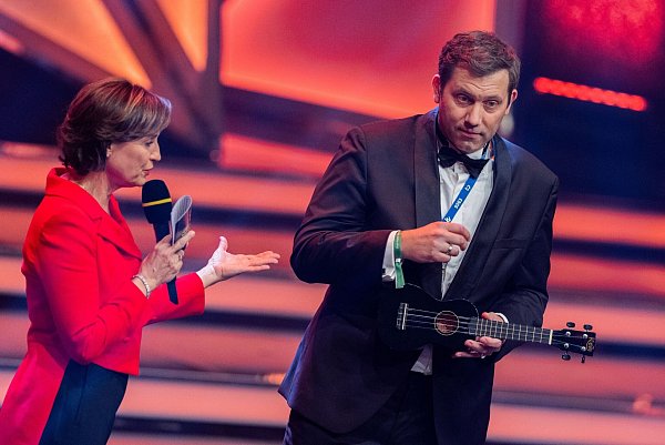 Der SPD-Vorsitzende Lars Klingbeil spielt Ukulele neben Moderatorin Sandra Maischberger. - © Rolf Vennenbernd/dpa