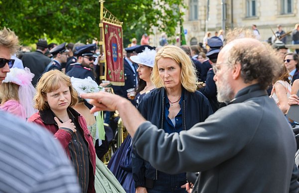 Die Schauspielerinnen Luise von Stein (l) und Maria Furtwängler stehen bei Dreharbeiten für einen neuen fiktiven „Tatort“ inmitten des realen Schützenausmarsches am Neuen Rathaus. - © Julian Stratenschulte/dpa