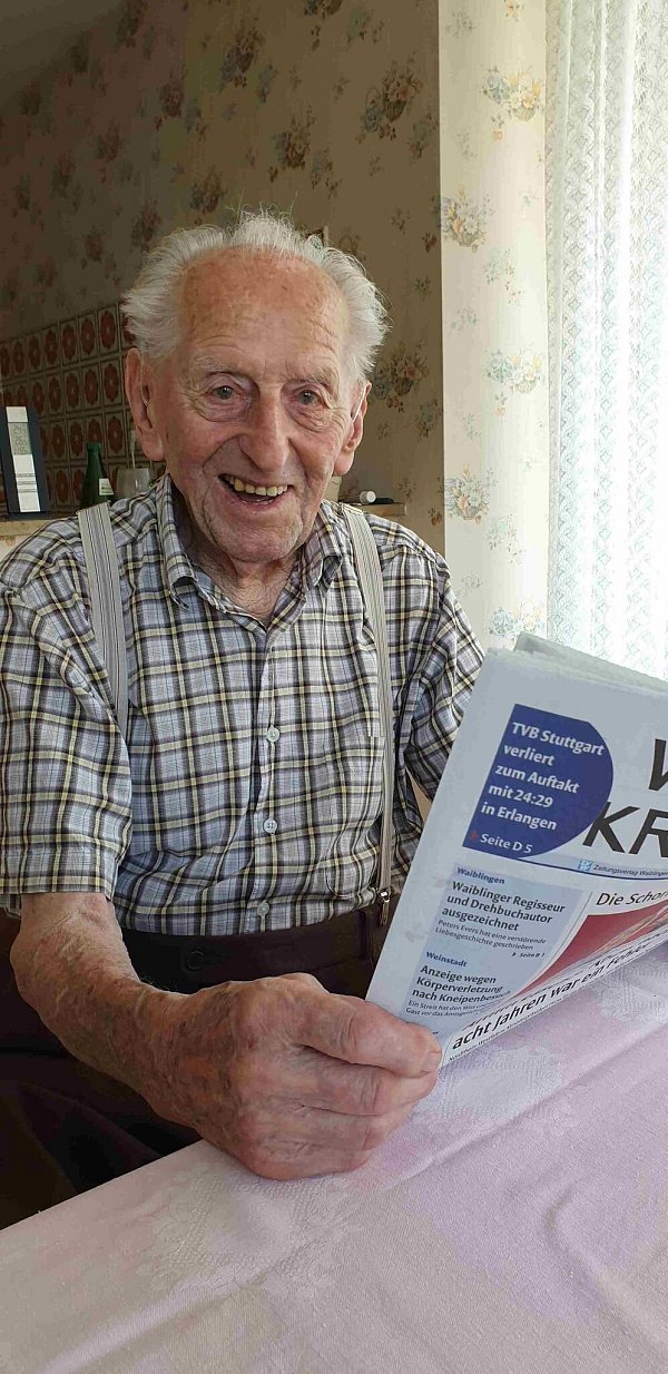 Karl Haidle sitzt an seinem 104. Geburtstag an einem Tisch und liest Zeitung. - © Sebastian Striebich/ZVW/dpa