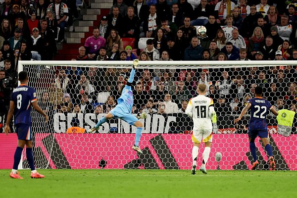Am Lattenschuss von Hollands Xavi Simons ist Oliver Baumann noch mit den Fingerspitzen dran. - © Christian Charisius/dpa