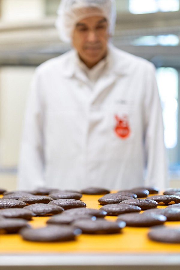 Frisch gebackene Lebkuchen laufen auf einem Band in der Produktion des Lebkuchenherstellers Schmidt. - © Daniel Karmann/dpa