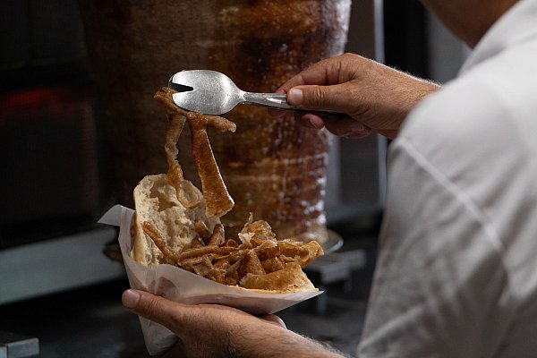 Vom Spieß ins Brot: Ein Mann bereitet einen Döner zu. (Archivbild) - © Markus Lenhardt/dpa