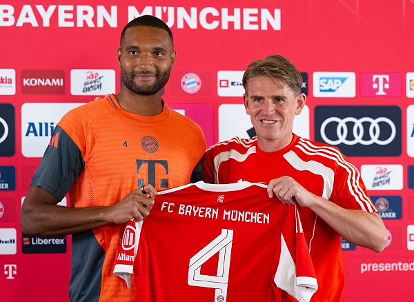Jonathan Tah (l) und Sportdirektor Christoph Freund. Der Nationalspieler wird beim FC Bayern im Trikot mit der Nummer vier auflaufen. - © Sven Hoppe/dpa