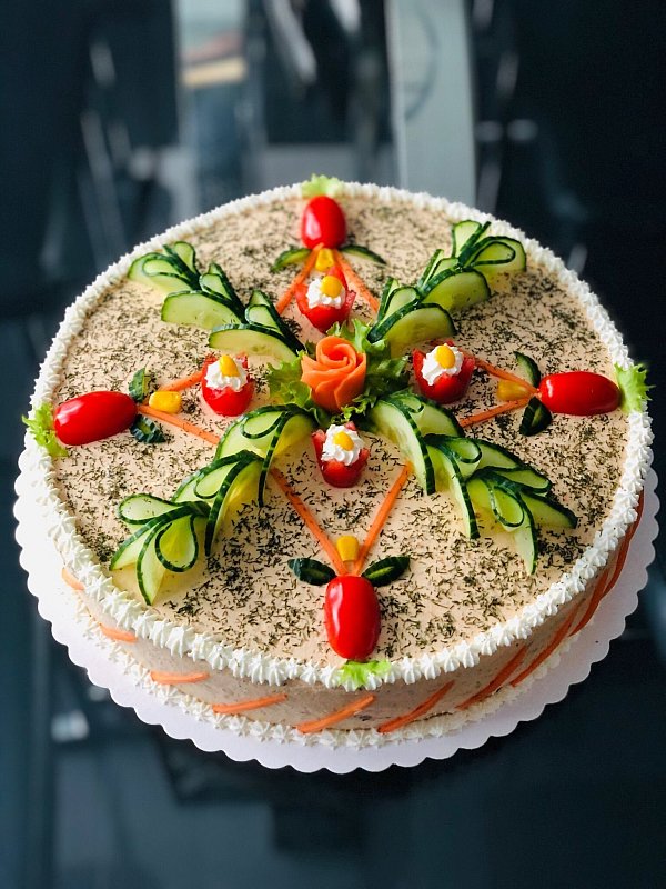 Eine Brottorte kann mit einer Salat-Gemüse-Mischung zwischen den Brotscheiben und wahlweise etwa mit Hähnchen, Lachs oder Gyros gefüllt werden. Als Verzierungen eignen sich geometrische Formen. - © Alina Eine/Tischlein deck dich - Café/dpa-tmn