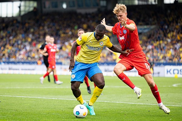 Der Braunschweiger Anthony Ujah (l) im Zweikampf mit dem Kieler Tom Rothe. - © Michael Matthey/dpa