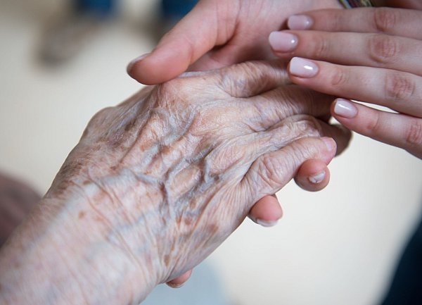 Alt und Jung: Eine Pflegerin hält die Hand einer Bewohnerin im Seniorenzentrum. Aber wie lange kann dieses Versorgungssystem noch funktionieren? (Symbolbild) - © Christophe Gateau/dpa