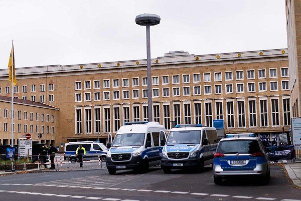 Die Polizei steht vor dem Zugang zu der Ausstellung "Nova Music Festival Exhibition" im ehemaligen Flughafen Tempelhof. - © Carsten Koall/dpa