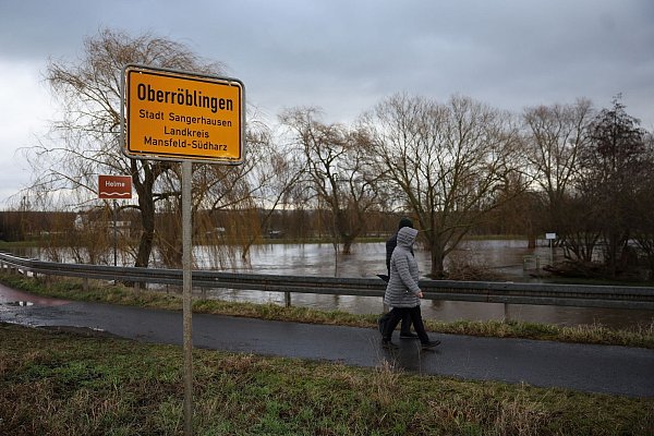Anwohner aus Oberröblingen auf einer vom Hochwasser umschlossenen Straße. Die Lage hier bleibt weiter angespannt. - © Jan Woitas/dpa