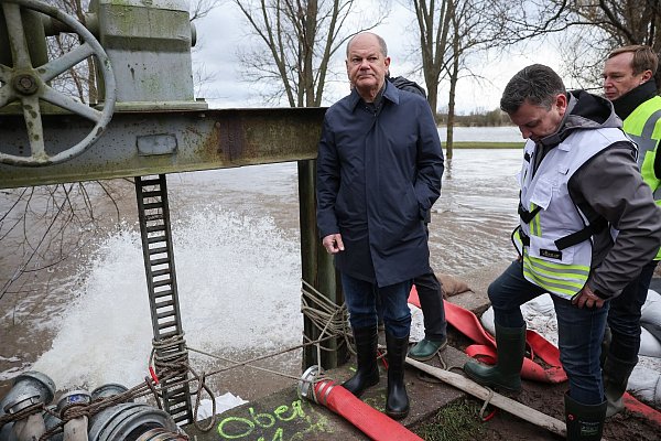 Bundeskanzler Olaf Scholz begutachtet ein Wehr in Sangerhausen. - © Jan Woitas/dpa