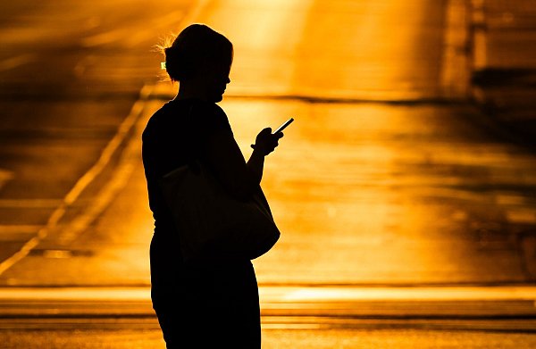 Eine Frau mit Handy - in der Netflix-Doku «Unbekannte Nummer: Der Highschool-Catfish» kommt der Psychoterror via Smartphone. (Symbolbild) - © Julian Stratenschulte/dpa