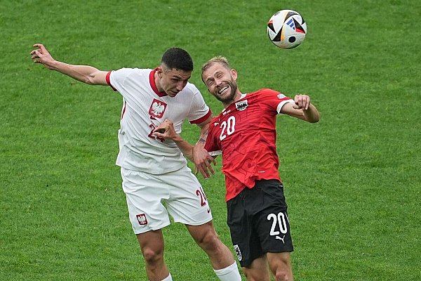 Polens Bartosz Slisz (l) im Kopfballduell mit dem Österreicher Konrad Laimer. - © Michael Kappeler/dpa