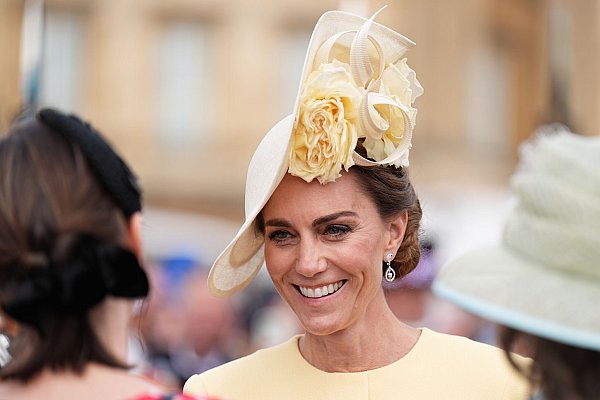 Bei der Gartenparty trug Kate ein pastellgelbes Kleid mit passendem Kopfschmuck, einem sogenannten Fascinator. - © Aaron Chown/PA Wire/dpa