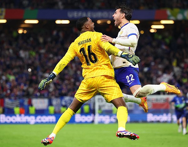 Frankreichs Torhüter Mike Maignan (l) jubelt mit Mitspieler Theo Hernandez nach dem entscheidenden Elfmeter. - © Jens Büttner/dpa