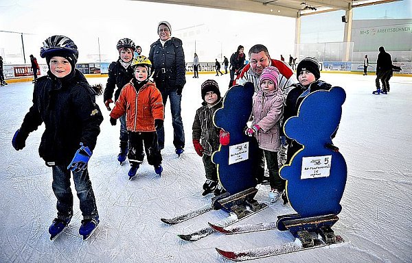 Felix, Sarah und Johanna (links von vorn), die mit ihrer Mutter Sandra Mertens das Schlittschuhlaufen lernen, kommen schon prima allein voran. Maria, Julia und Michael (rechts im Bild, v. l. ) brauchen noch ein bisschen Unterstützung von Papa Vladimir Poddubskij und üben mit den Laufhilfe-Bären. - © FOTO: M. KÖPPELMANN