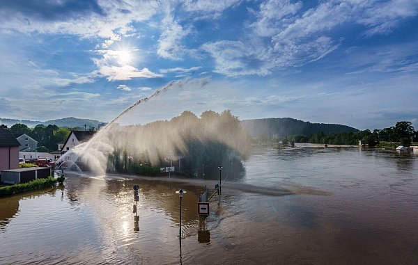 Mit riesigen Wasserfontainen befördert die Feuerwehr in Saarbrücken das Wasser aus den vollgelaufenen Kellern wieder zurück in die Saar. - © Andreas Arnold/dpa