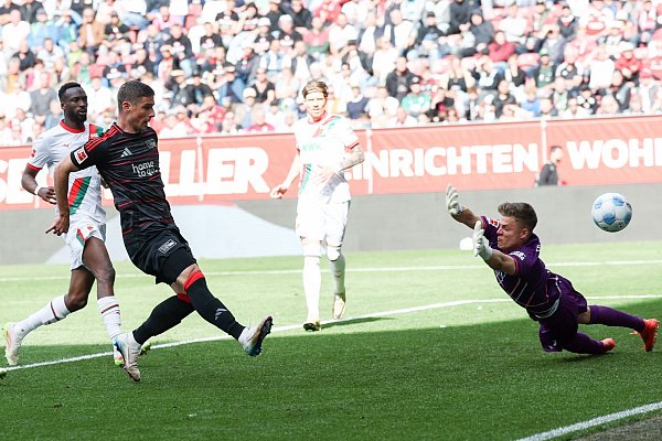 Berlins Matchwinner Andrej Ilic (l) bei seinem ersten Tor zum 1:1. FCA-Torwart Finn Dahmen ist chancenlos. - © Daniel Löb/dpa