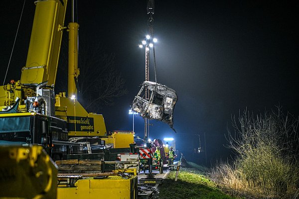 Mit einem großen Kran und unter Flutlicht werden Trümmerteile geborgen. - © Jason Tschepljakow/dpa