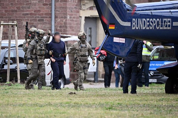 Eine Person wird von Polizeibeamten zu einem Hubschrauber gebracht. - © Uli Deck/dpa